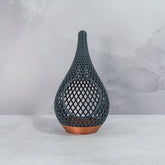 "Sitting, front-facing, empty COPPER AND CARBON TEARDROP planter, showcasing its striking design with a carbon fibre pattern."